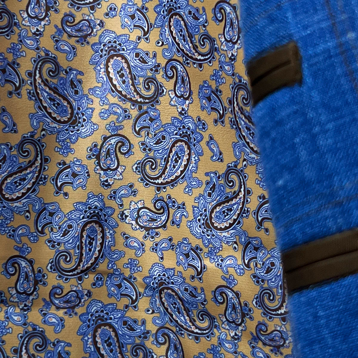 Decorative flash lining accents visible at jacket cuffs and interior edges featuring coordinated brown paisley pattern