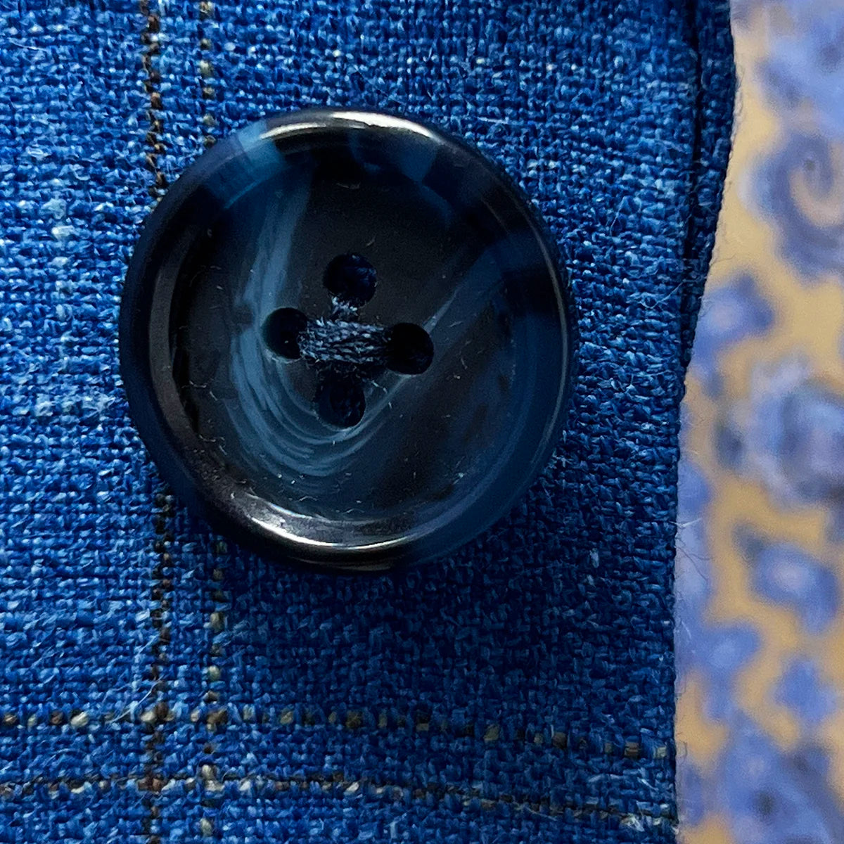 Detail shot of genuine navy horn buttons displaying natural marble patterns and premium button quality