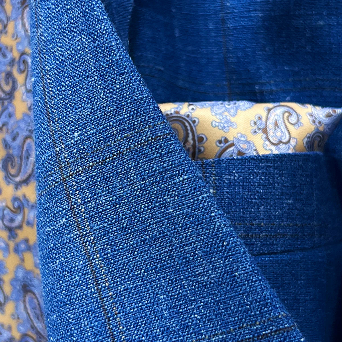 Chocolate brown contrast accent buttonholes on jacket front and sleeves demonstrating custom detailing