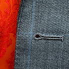 Detailed macro shot of hand-finished buttonhole stitching on light gray with light blue windowpane sport coat with bright orange contrast thread