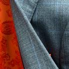 Detailed fabric texture view of Super 130's merino wool showing light gray base with light blue windowpane pattern