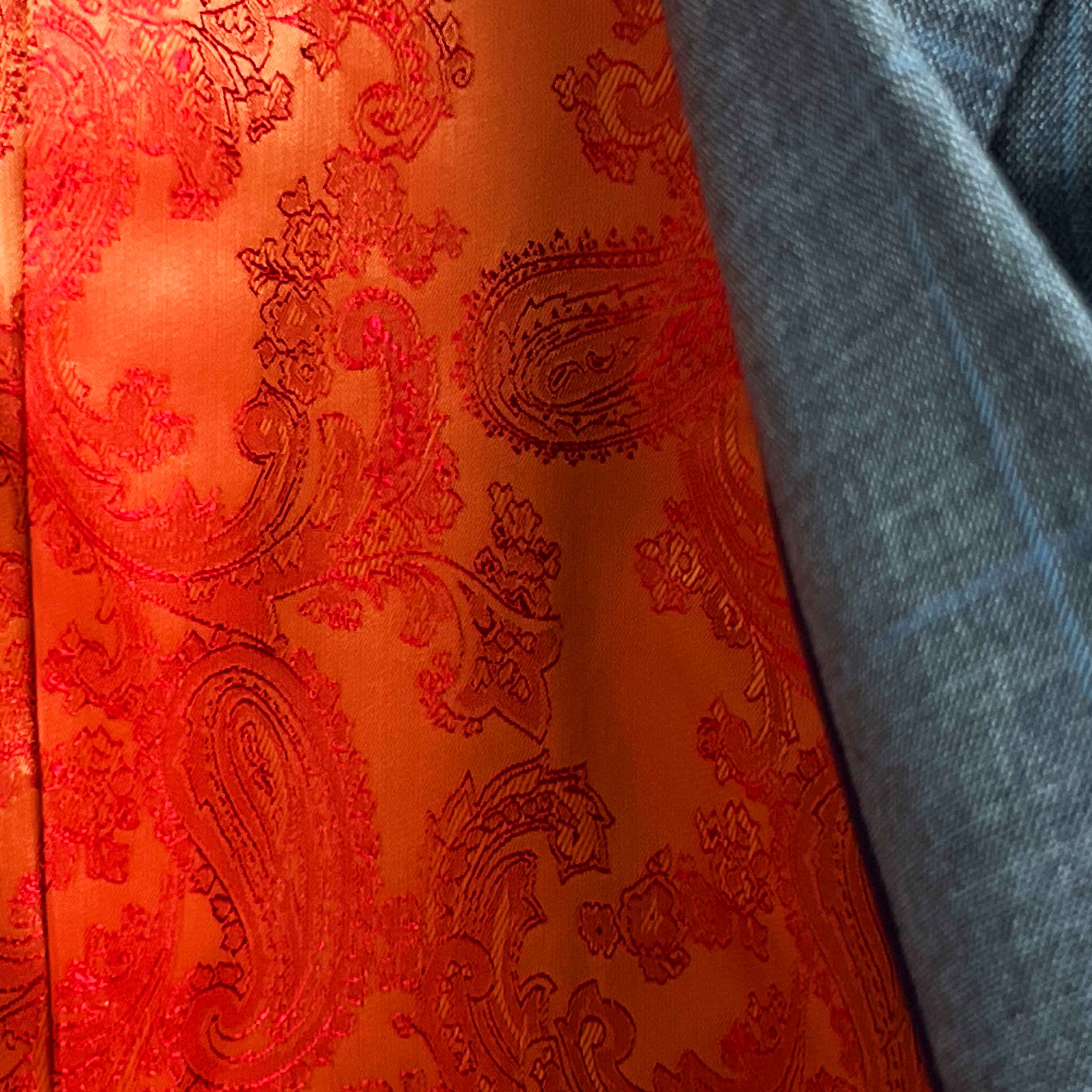Colorful flash lining detail visible at jacket cuffs and vents in bright orange paisley jacquard pattern