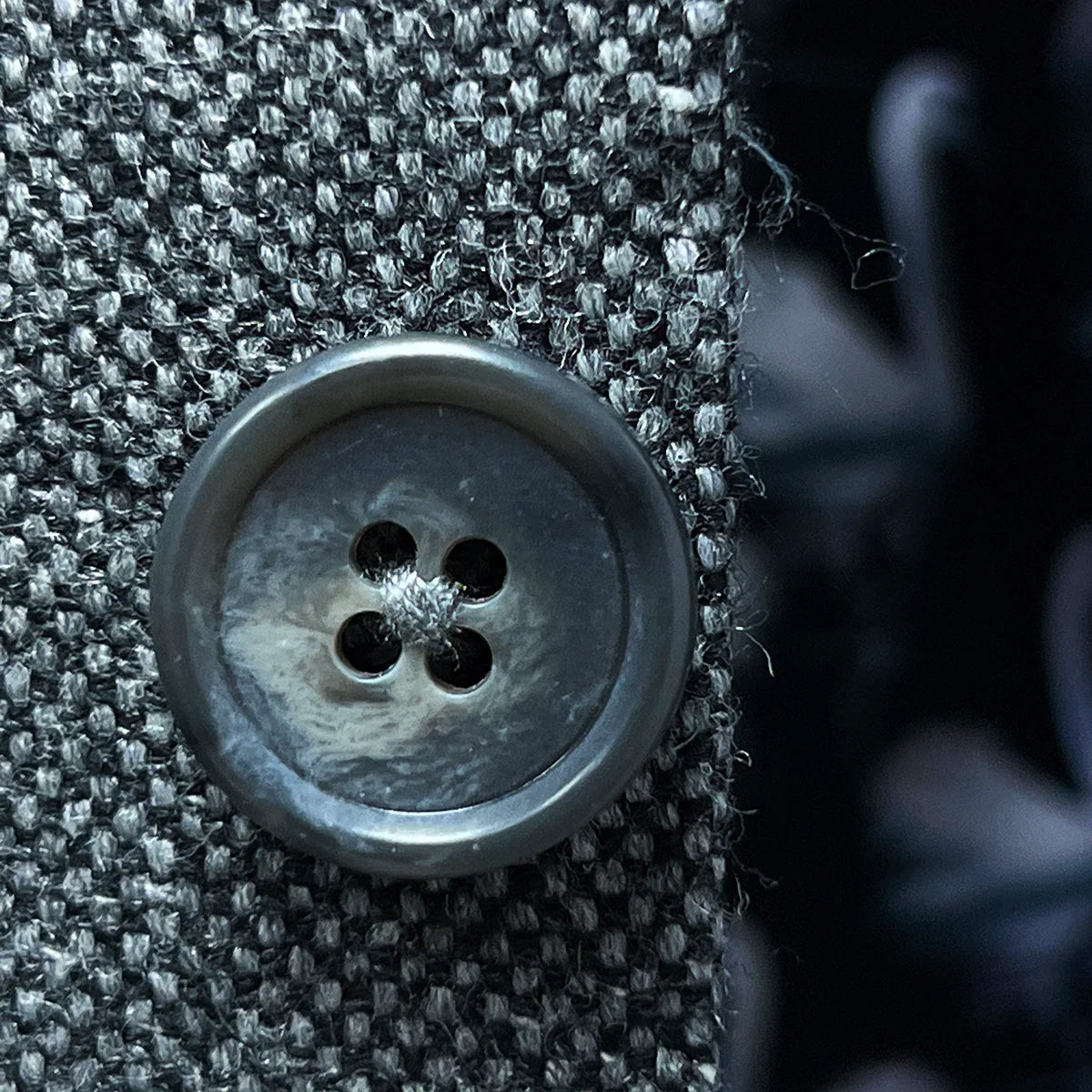 Macro shot of light grey horn marble buttons showing natural variations and luxury detail