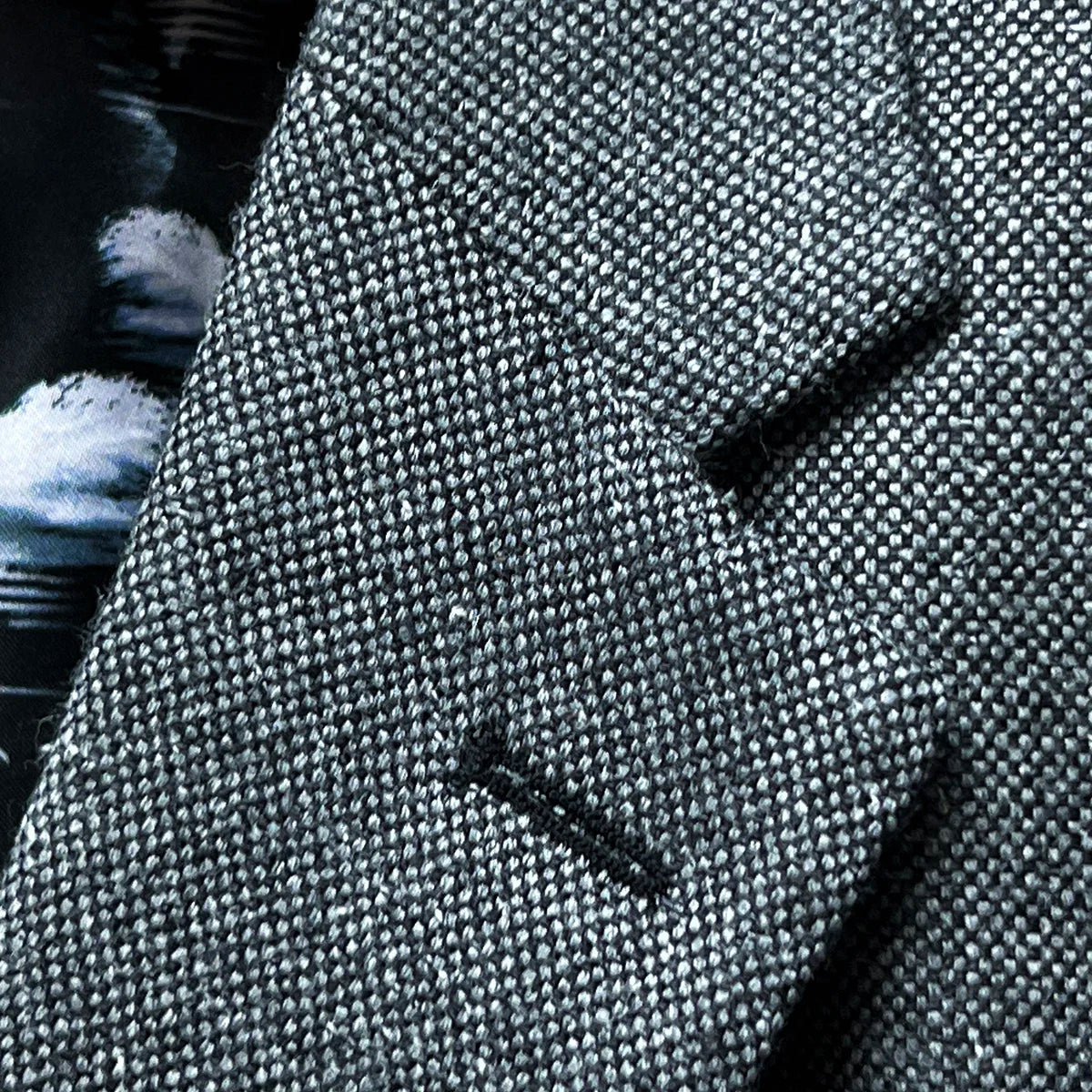 Close-up of notch lapel construction with black contrast buttonhole and pick stitching detail