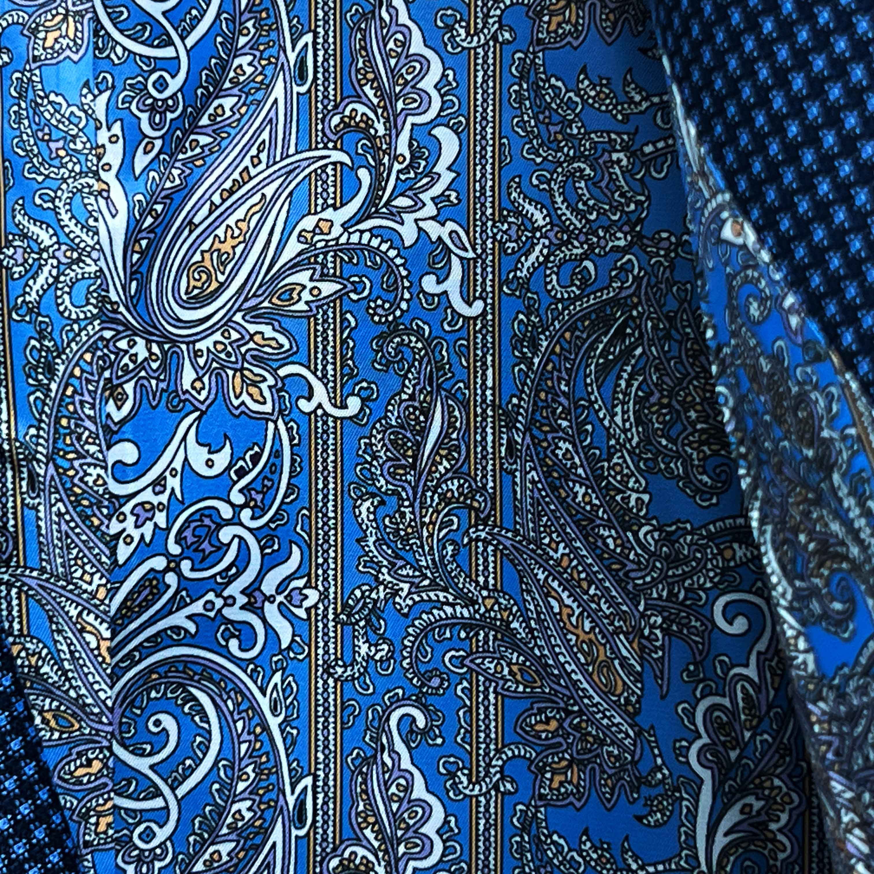 Colorful flash lining detail visible at jacket cuffs and vents in blue, white and gold paisley pattern