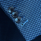 Sport coat sleeve cuff showing functional buttonholes with contrast light blue accent stitching on medium blue micro check fabric