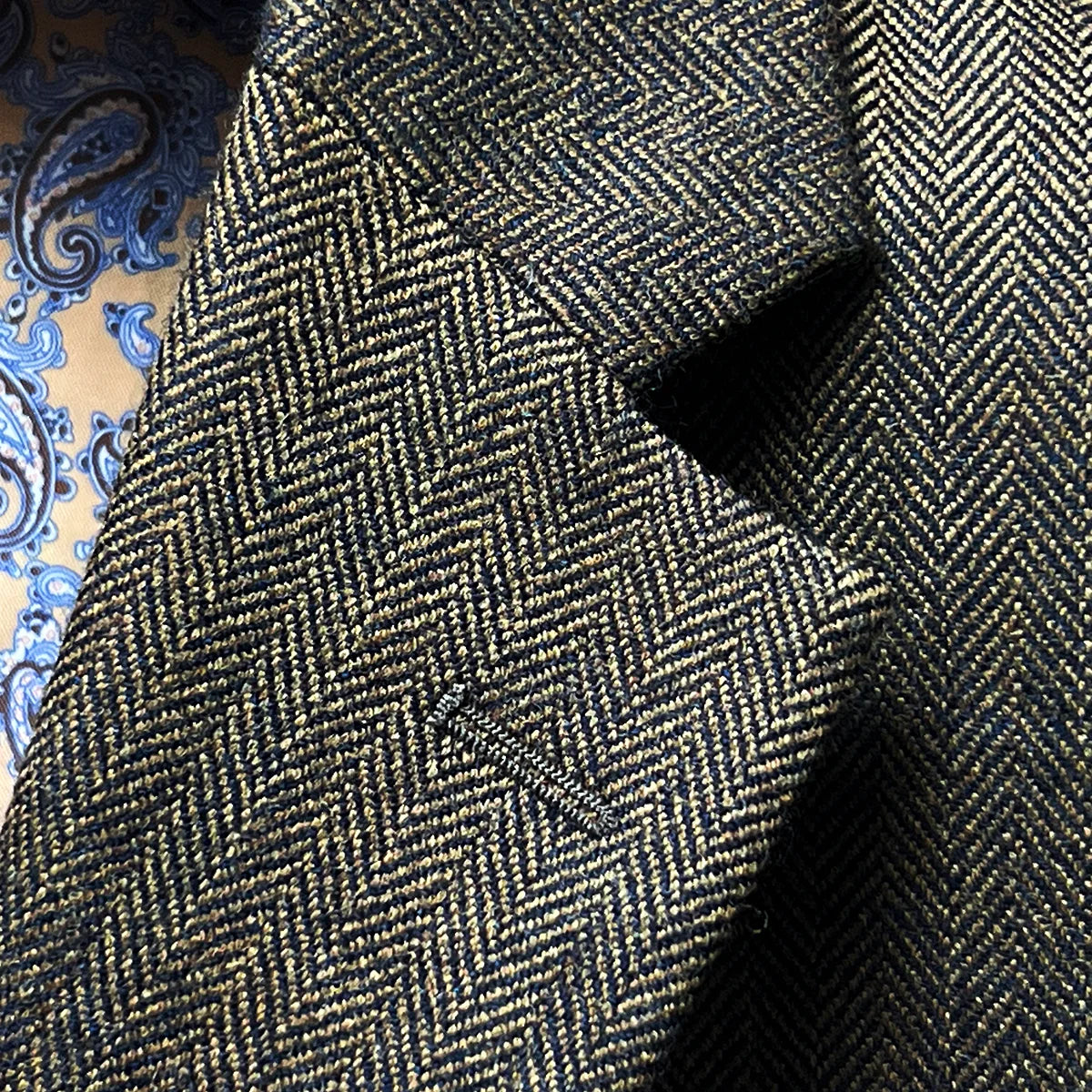 Classic notch lapel detail showing proper proportions, gorge placement, and herringbone pattern flow across lapel construction