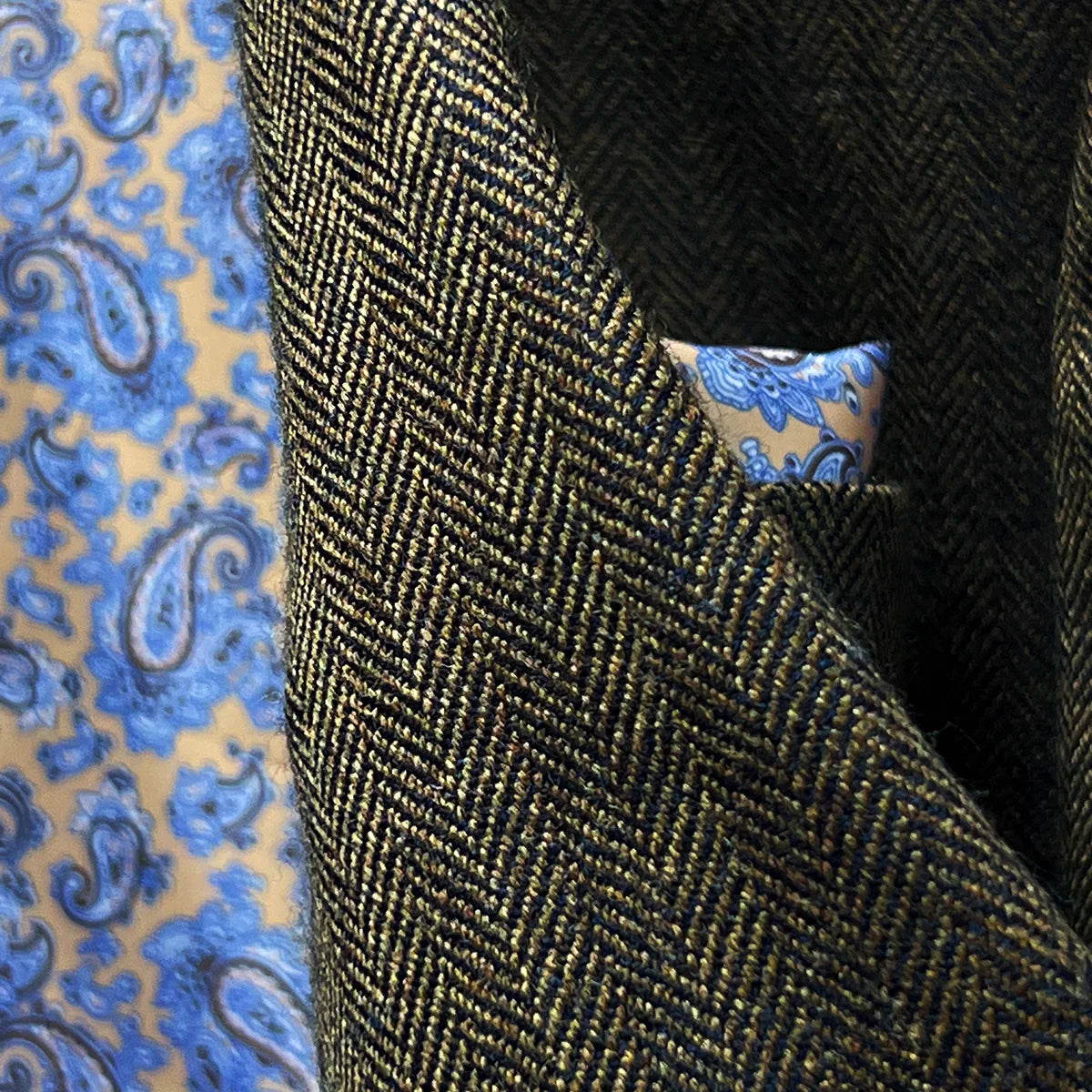 Decorative contrast stitching on buttonholes adding subtle design element to complement paisley lining accents