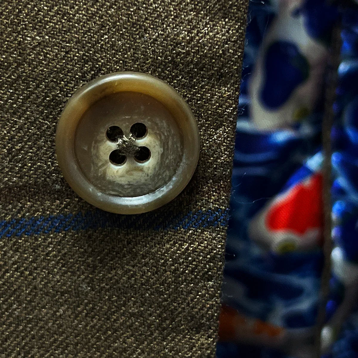 Close-up of sport coat's brown horn buttons, showing natural marbling and texture