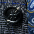 Macro shot of an unfastened grey marble horn button, revealing the natural patterns and depth of color in these premium suit fastenings