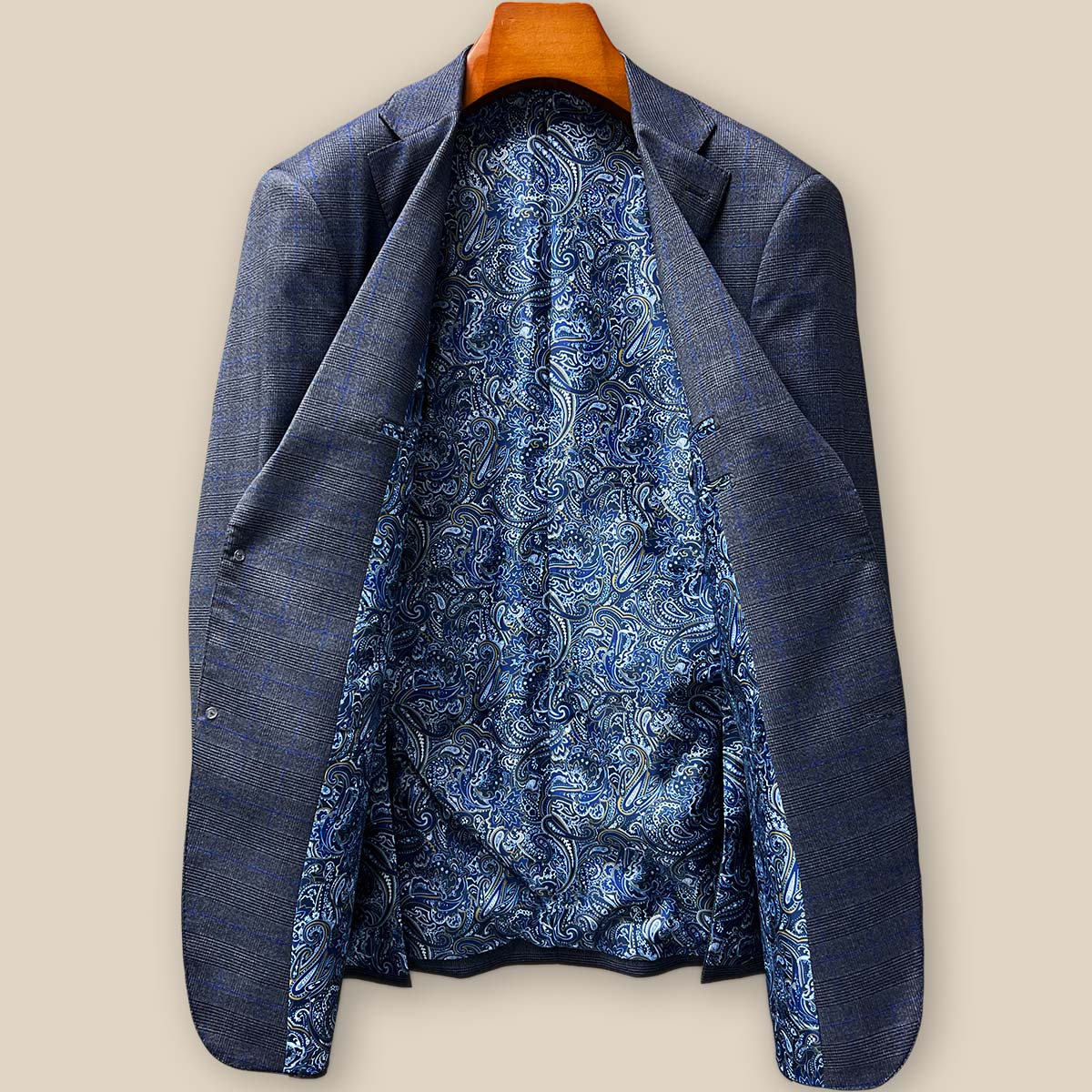 Full spread view of the bespoke suit jacket's striking blue paisley lining with gold and white accents, showcasing the hidden luxury that elevates this tailored garment