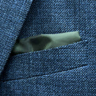 Breast pocket of medium steel blue hopsack sport coat with built-in pocket square holder and hand-finished edges
