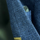 Close-up of medium steel blue hopsack weave fabric texture showing distinctive basket weave pattern and melange effect