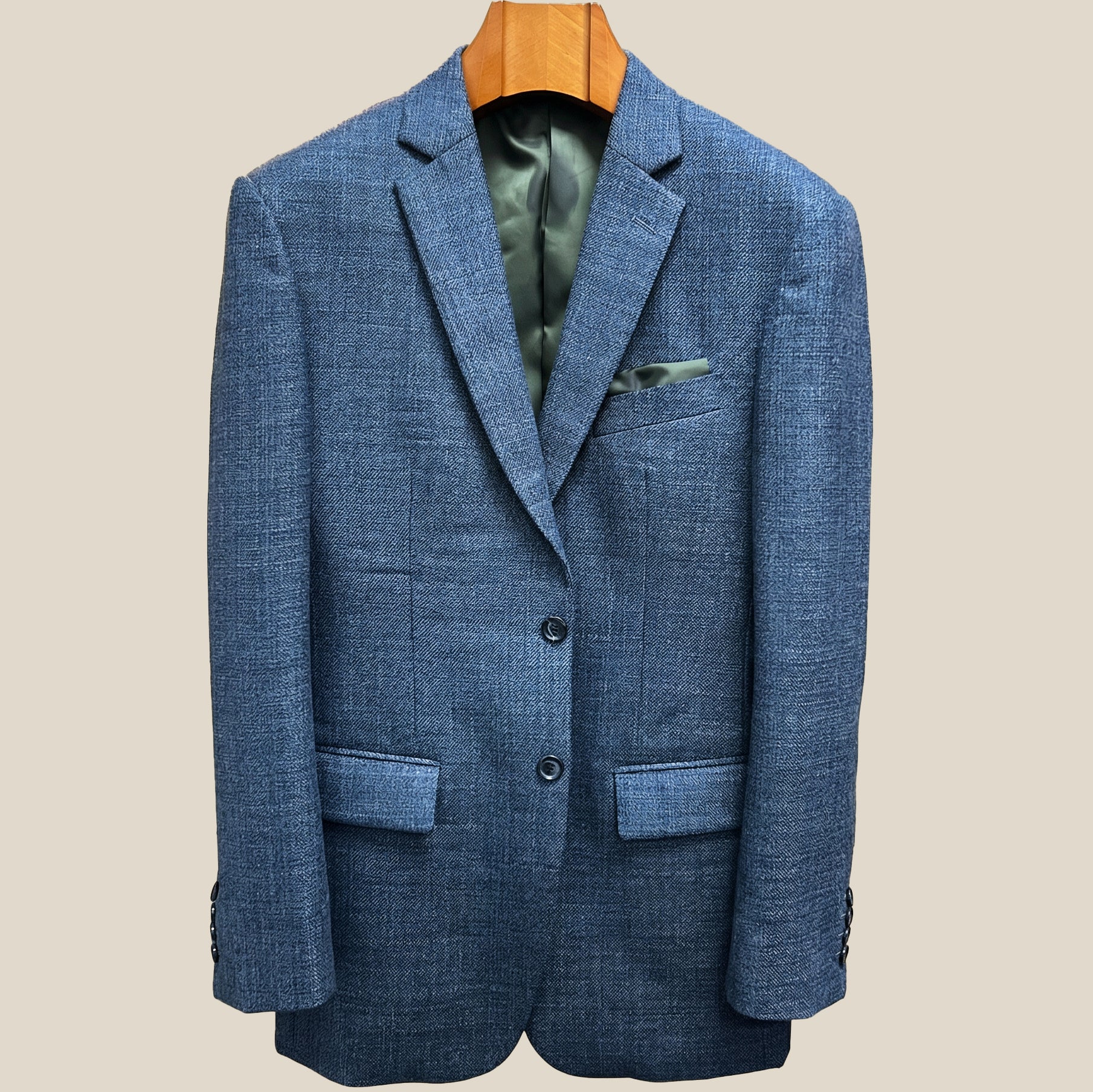 Front button panel of medium steel blue hopsack sport coat featuring dark navy horn buttons with light blue marbling and hand pick stitching