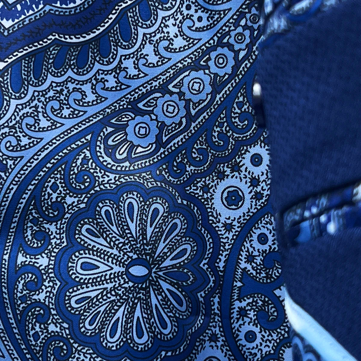 Colorful flash lining detail visible at jacket cuffs and vents in rich blue intricate paisley pattern