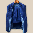 Complete two-piece navy blue geometric textured custom suit displayed on hanger showing jacket and trousers