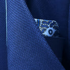 Close-up detail of geometric textured pattern on navy blue suit fabric showing intricate weave structure