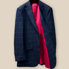 Interior view of navy windowpane suit jacket, displaying tomato red silk bemberg lining and left chest pocket