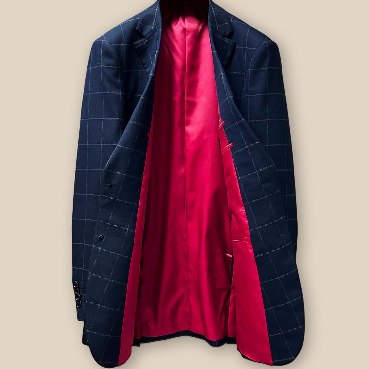 Full interior view of navy windowpane suit jacket, showcasing vibrant tomato red silk bemberg lining