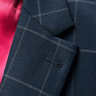 Detail of semi-notch lapel on navy windowpane suit jacket, showing lapel roll and stitching