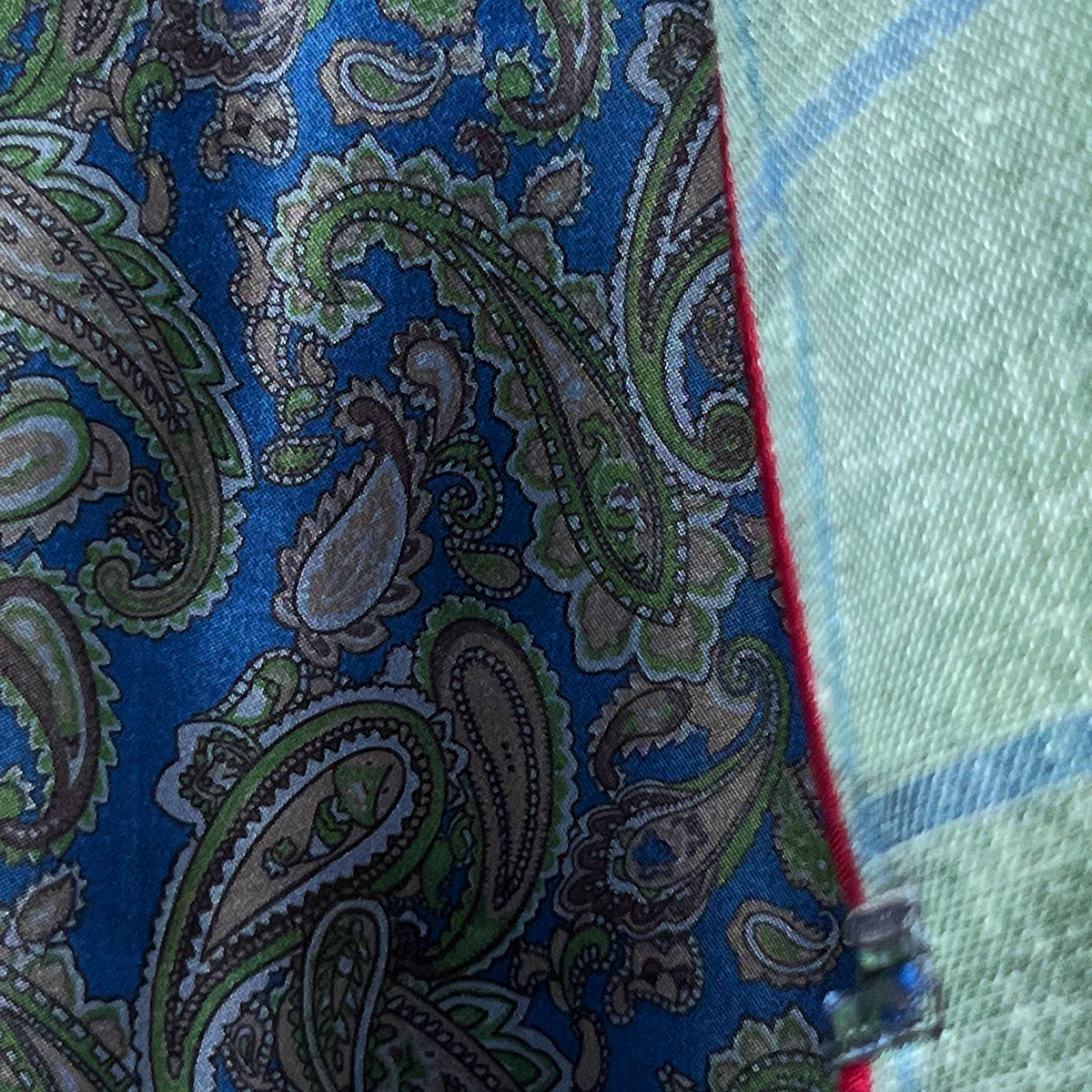 Dramatic flash lining reveal showing vibrant blue paisley pattern with maroon piping as jacket moves during wear
