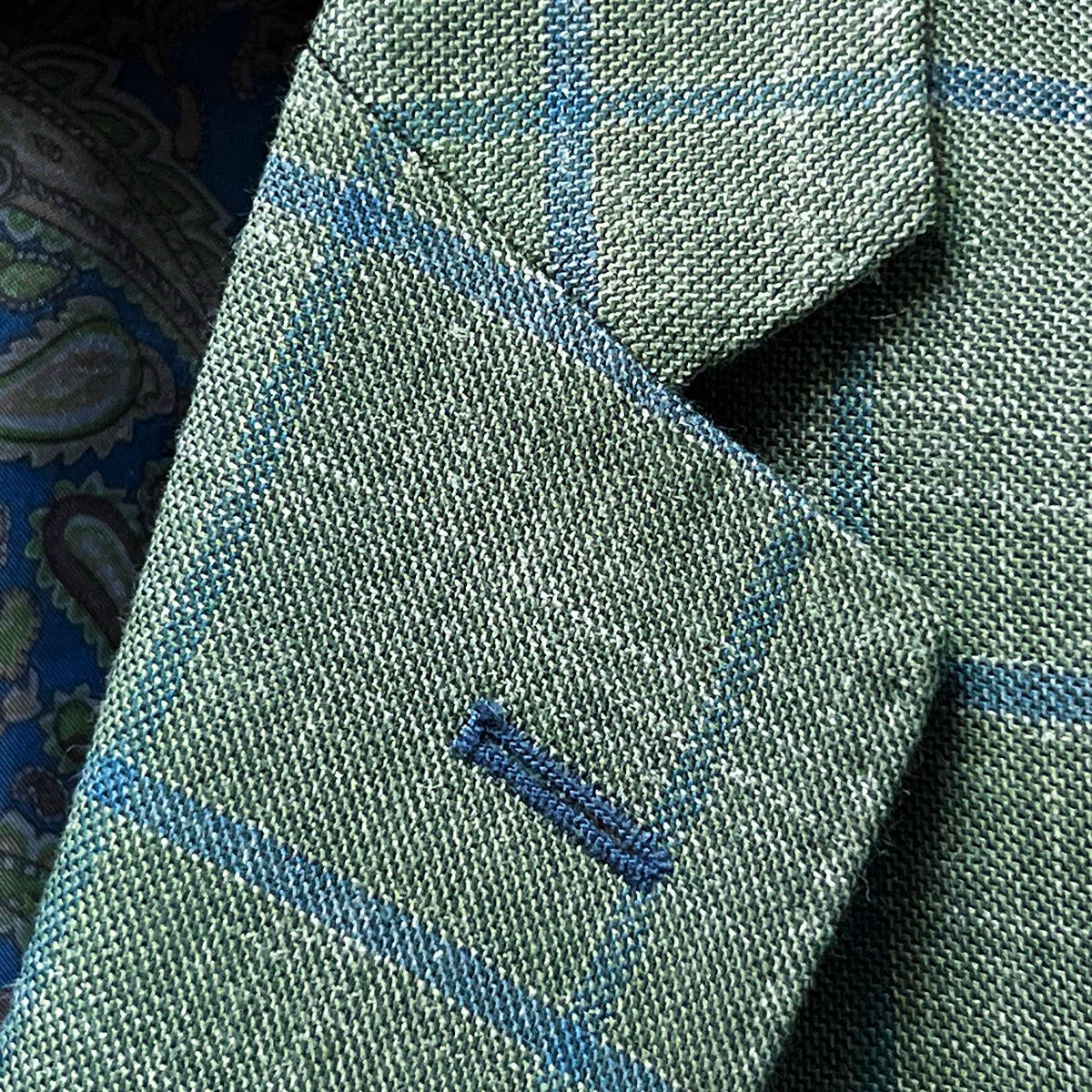 Classic notch lapel construction in olive green windowpane fabric with royal blue contrast buttonhole and expert canvas work
