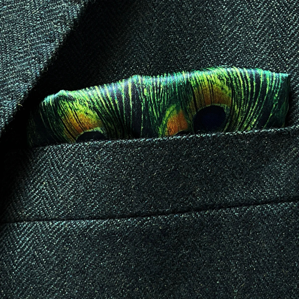 Built-in pocket square feature in matching olive herringbone tweed with complementary border detail