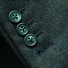 Working sleeve buttonholes with black contrast stitching on olive tweed sport coat featuring green horn buttons