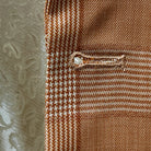 Macro view of buttonhole stitching on orange Prince of Wales glen plaid fabric