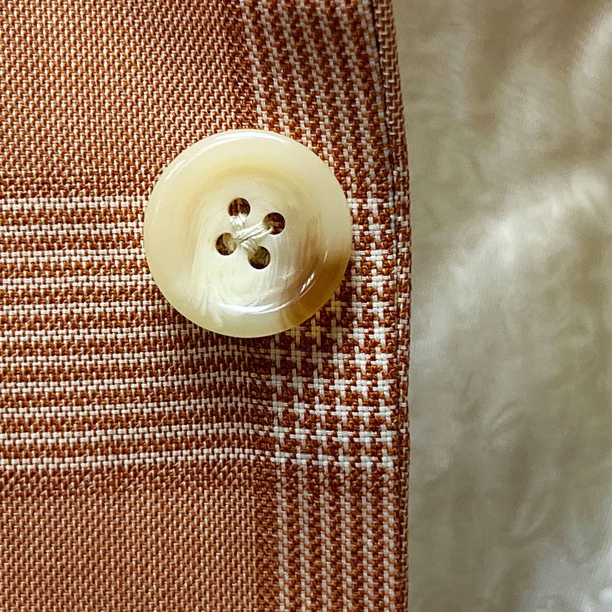 Detailed view of ivory marble horn buttons used on the suit jacket and vest