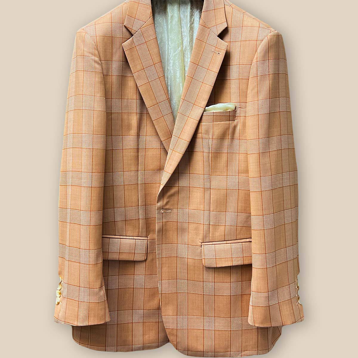 Close-up of orange Prince of Wales glen plaid suit jacket showing single button closure and buttonhole detail