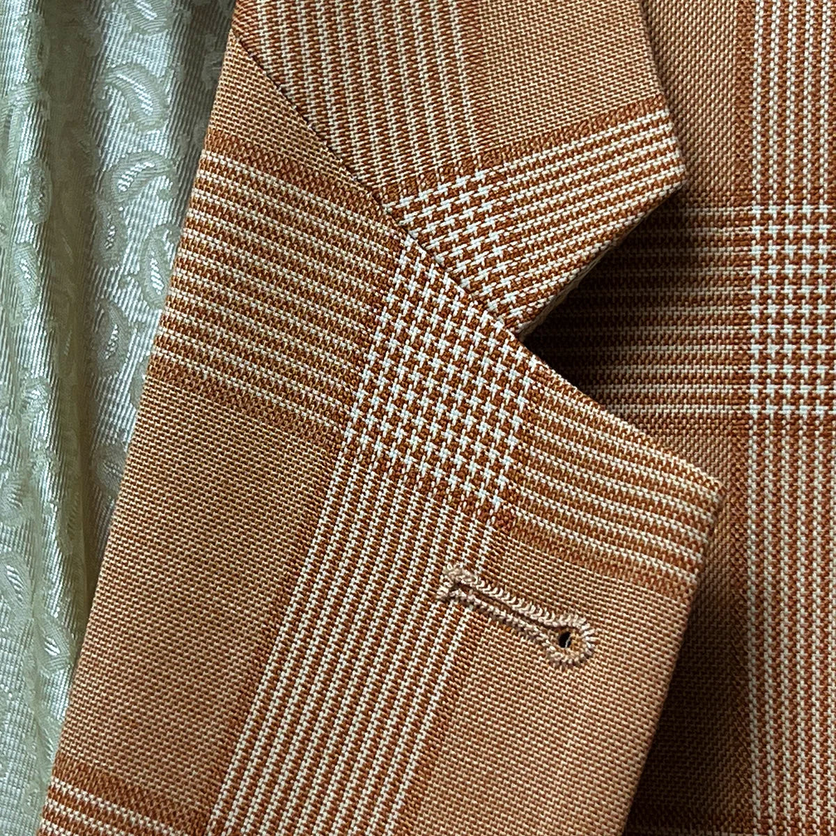 Detail of suit jacket's notch lapel, showcasing the Prince of Wales glen plaid pattern