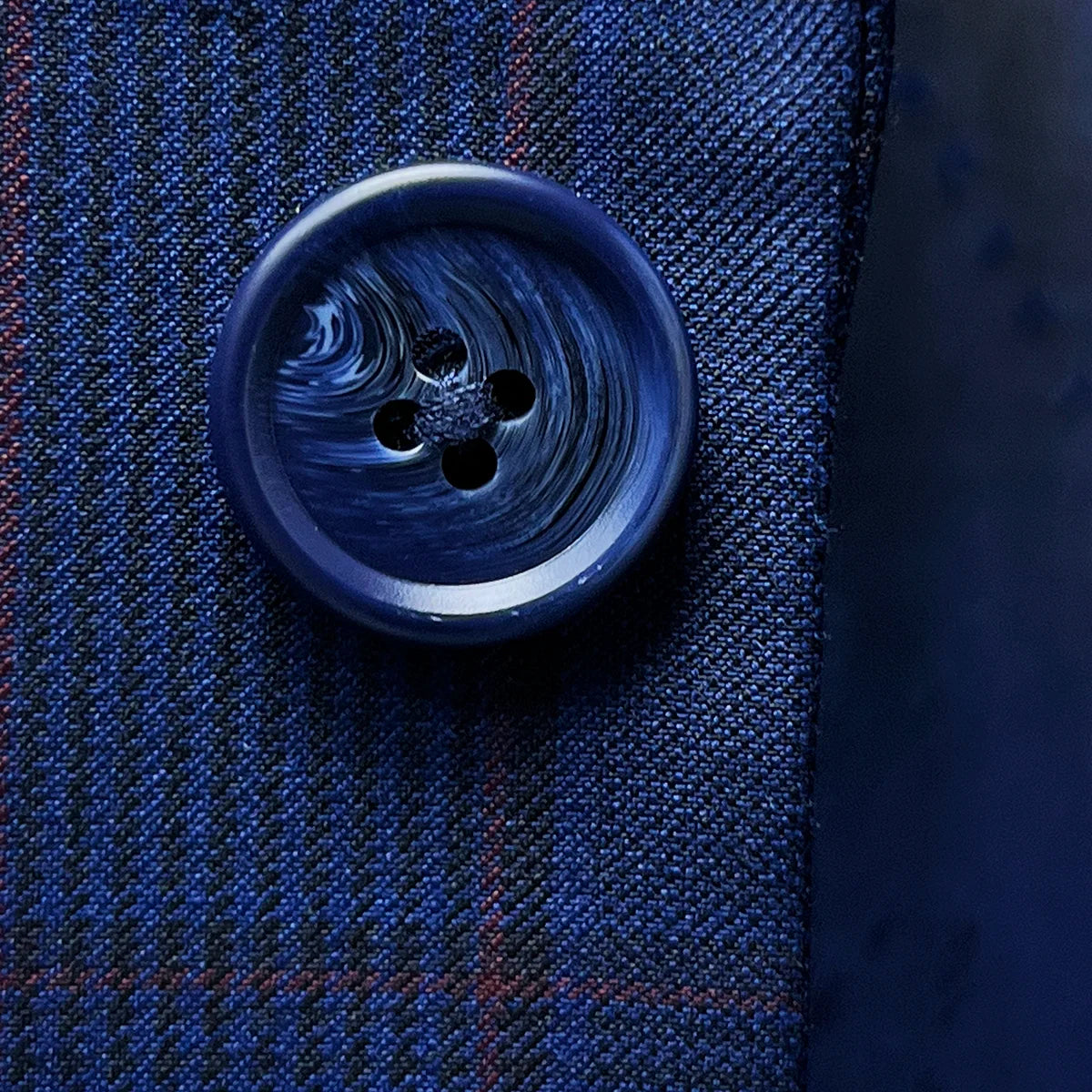 Artistic close-up of navy marble horn buttons displaying natural texture and sophisticated color coordination
