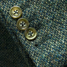 Close-up of working sleeve buttonholes with green horn buttons on tweed fabric