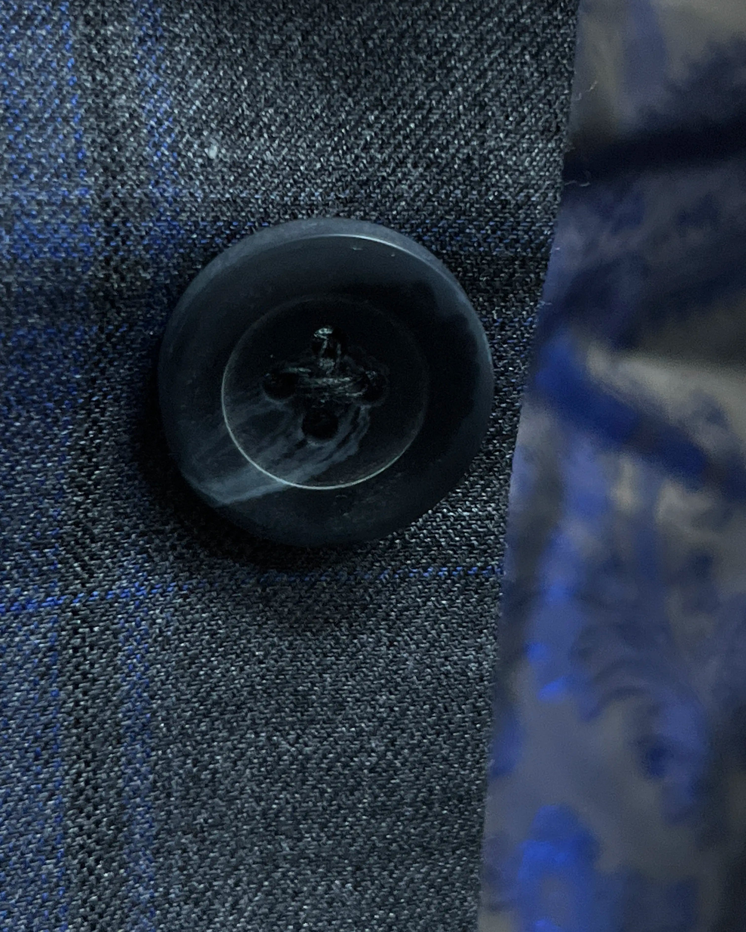 Button close up of charcoal grey royal blue windowpane men's sport coat showing dark grey horn buttons
