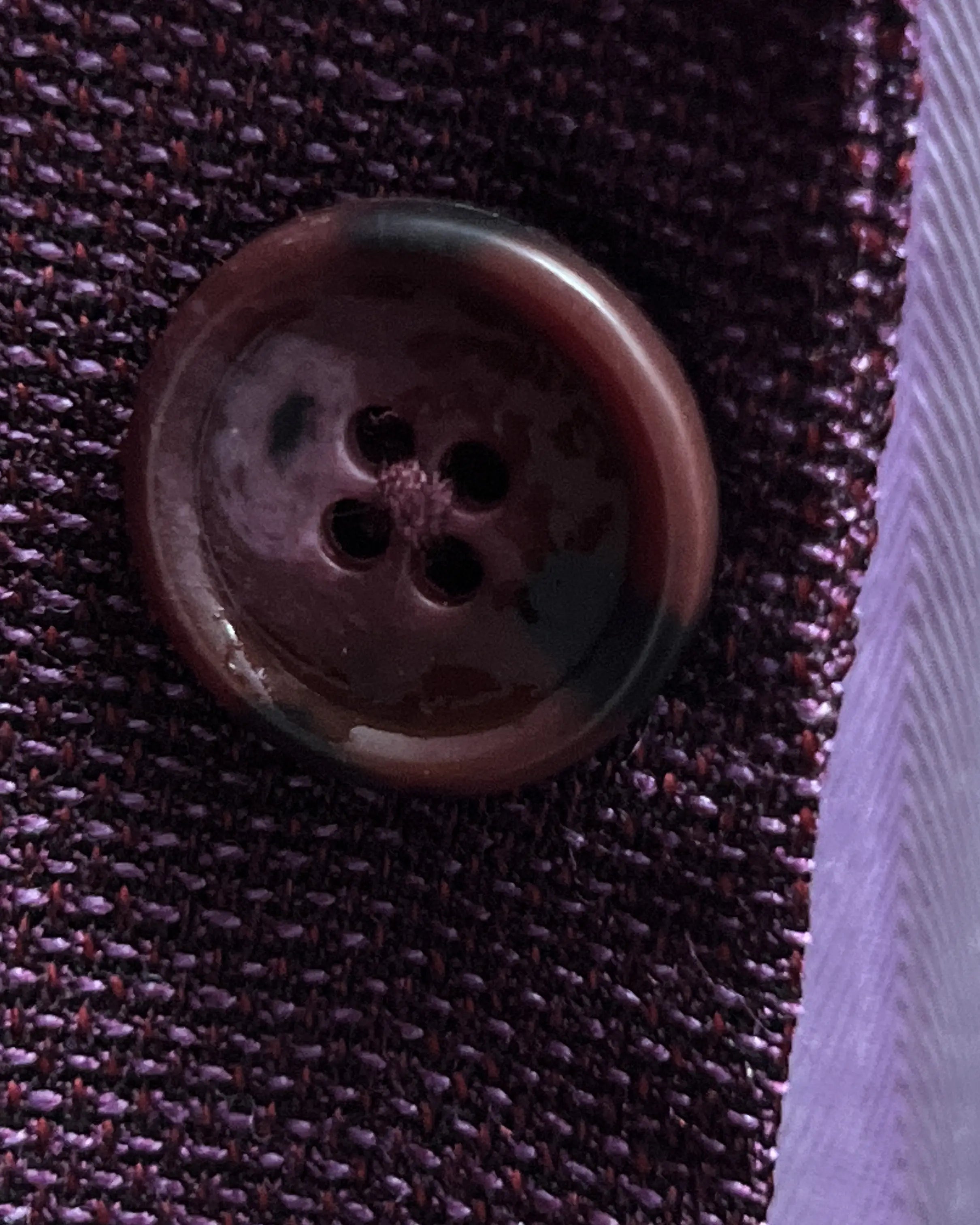 Button detail of deep plum burgundy birdseye men's sport coat showing dark burgundy horn buttons