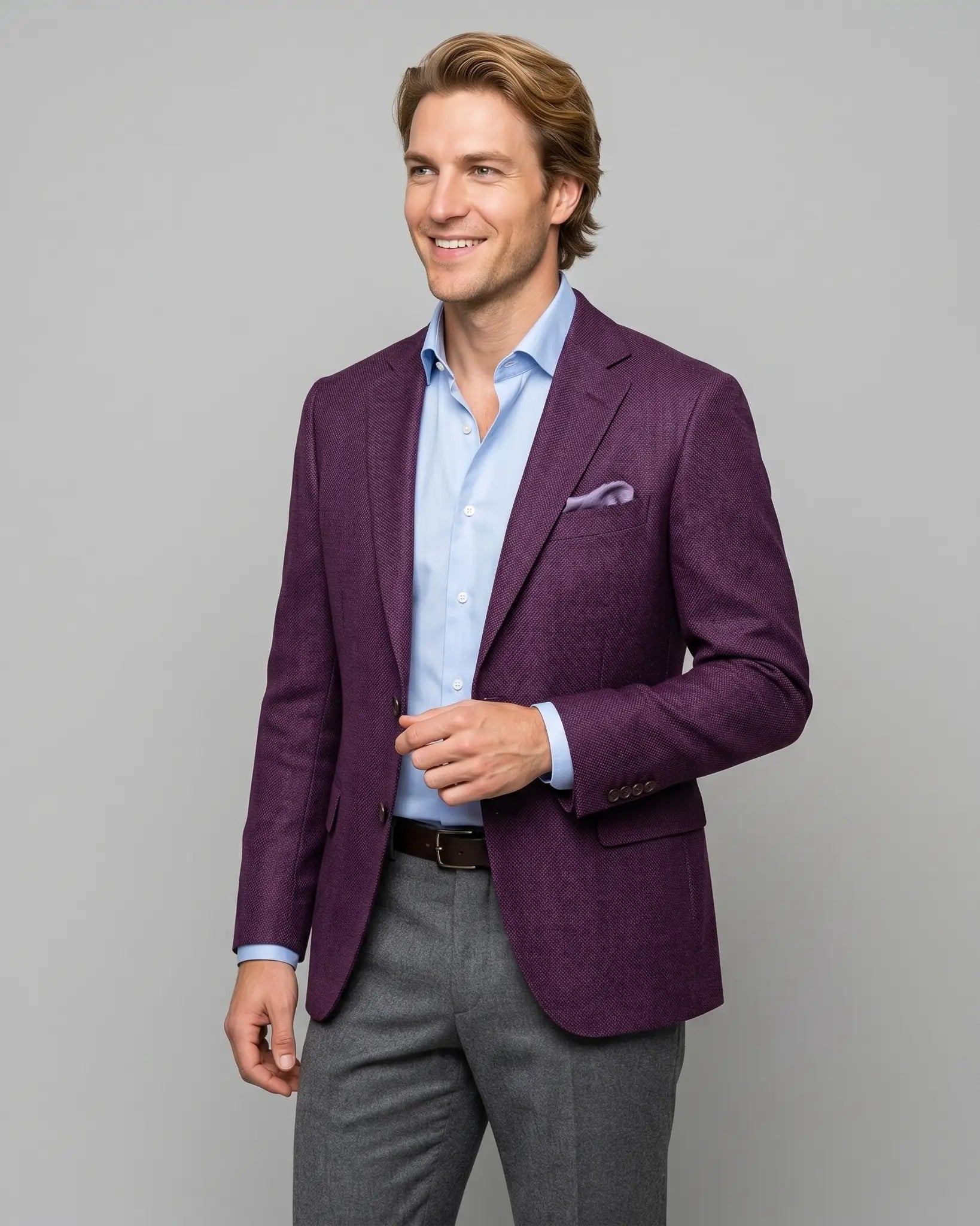 Side model view of deep plum burgundy birdseye men's sport coat showing angled editorial styling