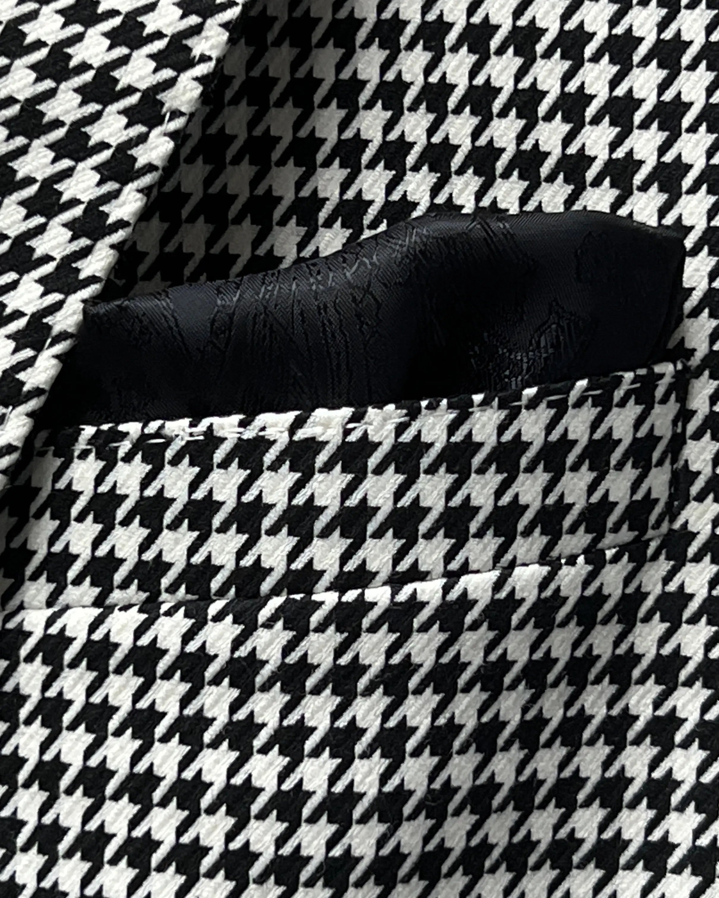 Breast pocket detail of High Contrast Black and White Houndstooth men's sport coat showing the matching black paisley silk bemberg pocket square.