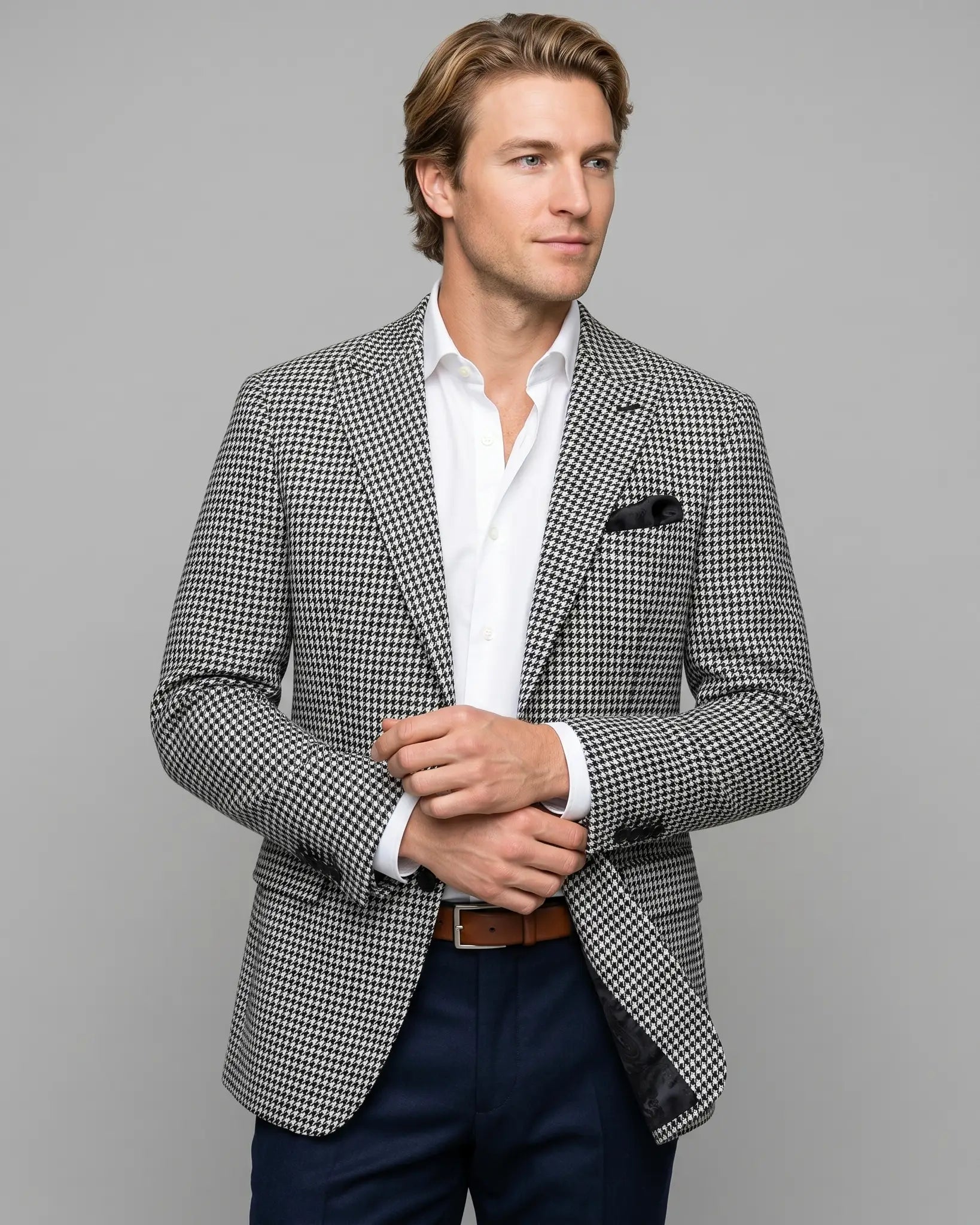 Angled model view of High Contrast Black and White Houndstooth men's sport coat showing the lapel roll and subtle lining glimpse.