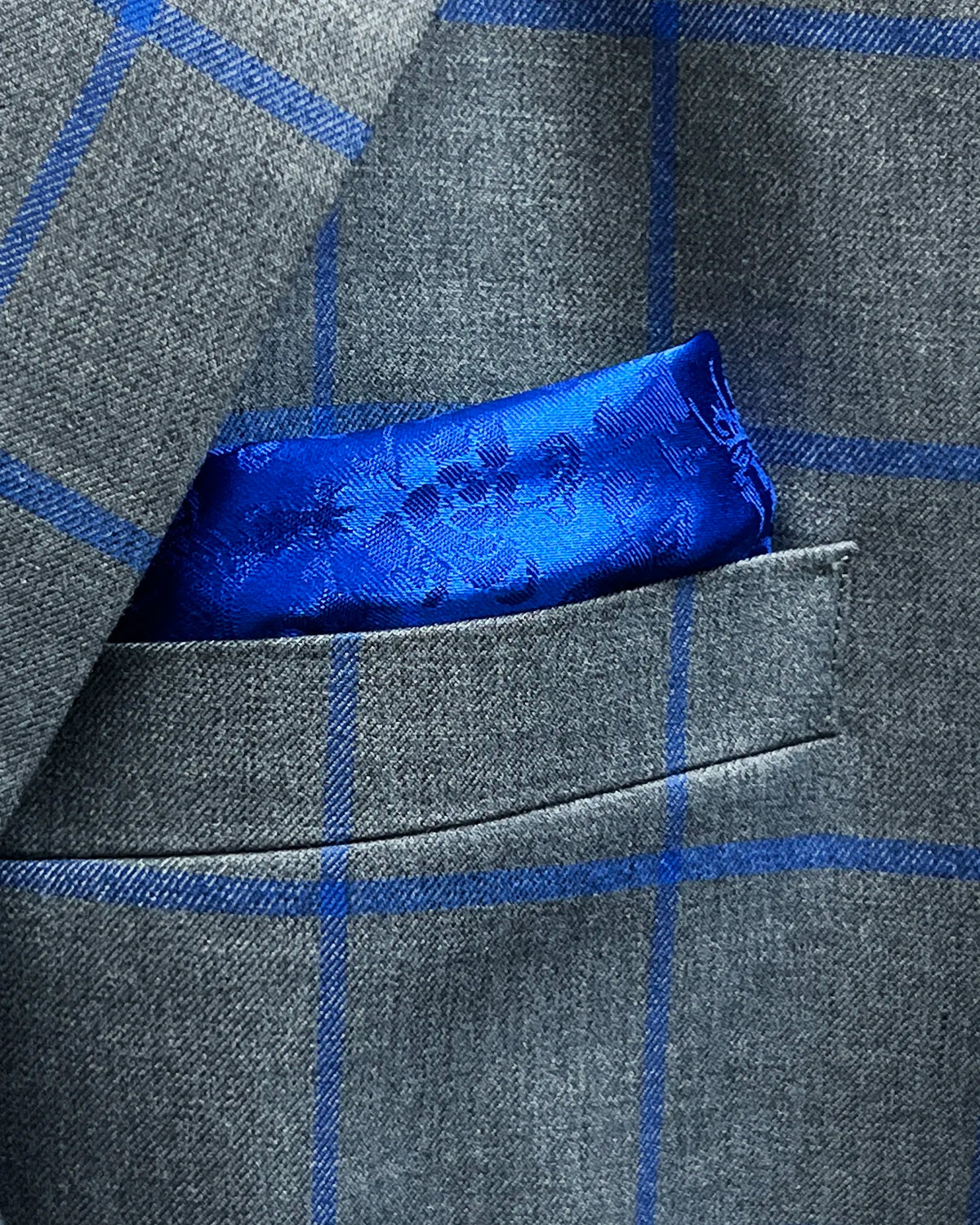 Built in lining pocket square of mid heather grey royal blue windowpane men's sport coat showing matching royal blue floral lining