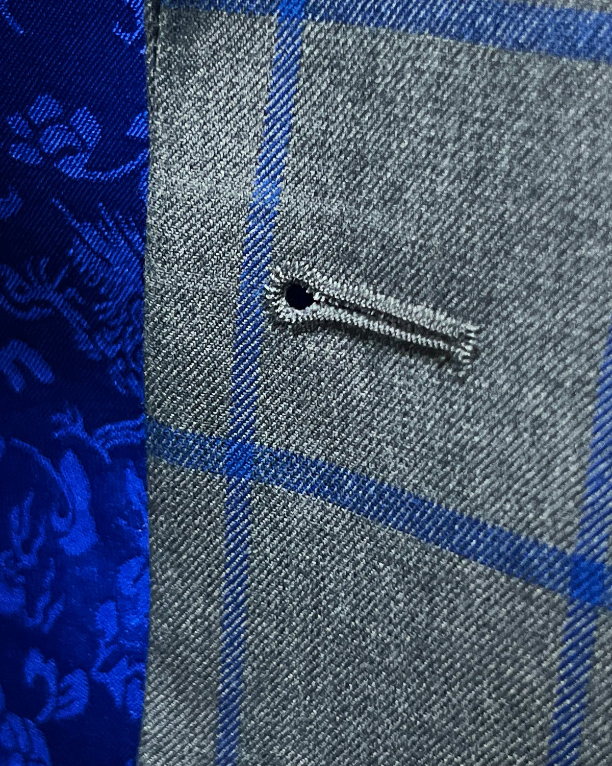 Buttonhole detail of mid heather grey royal blue windowpane men's sport coat showing the front buttonhole