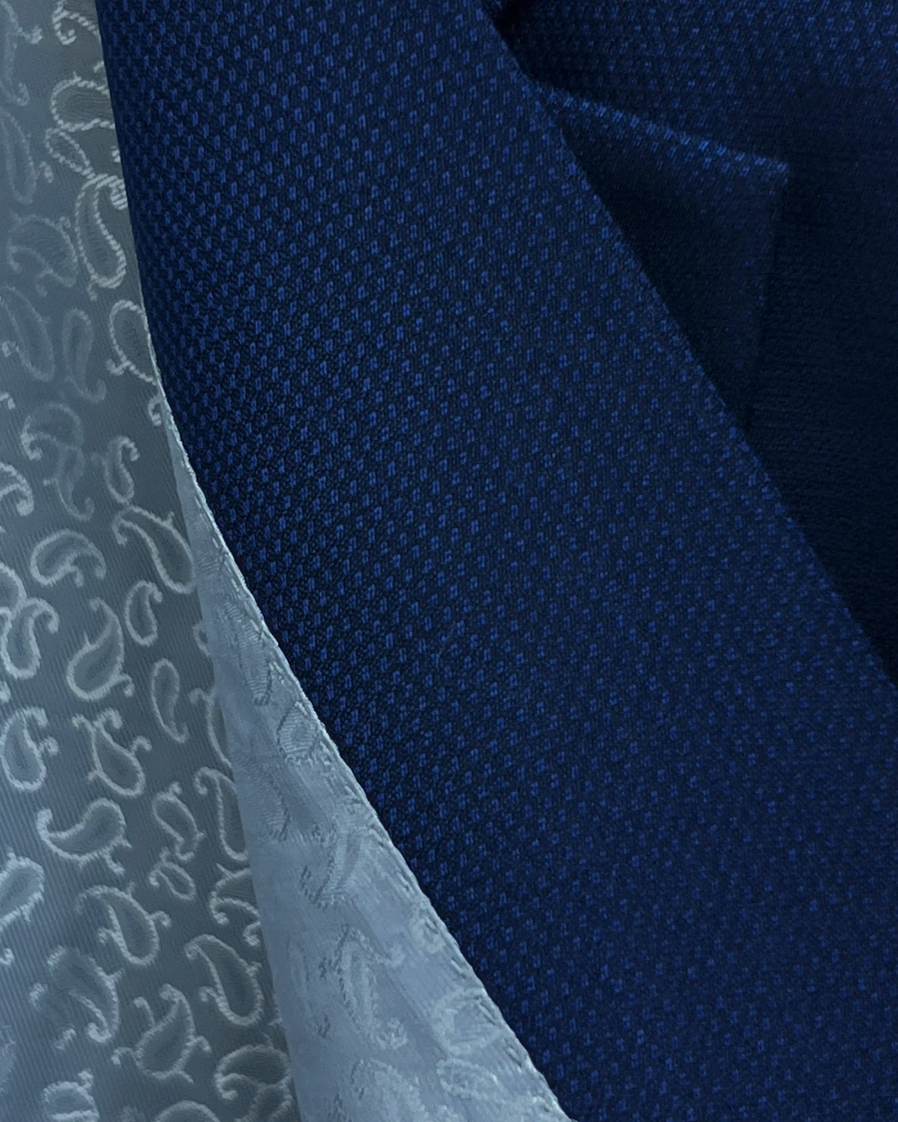 Fabric macro of Royal blue Birdseye men's sport coat showing the finely granular geometric weave texture
