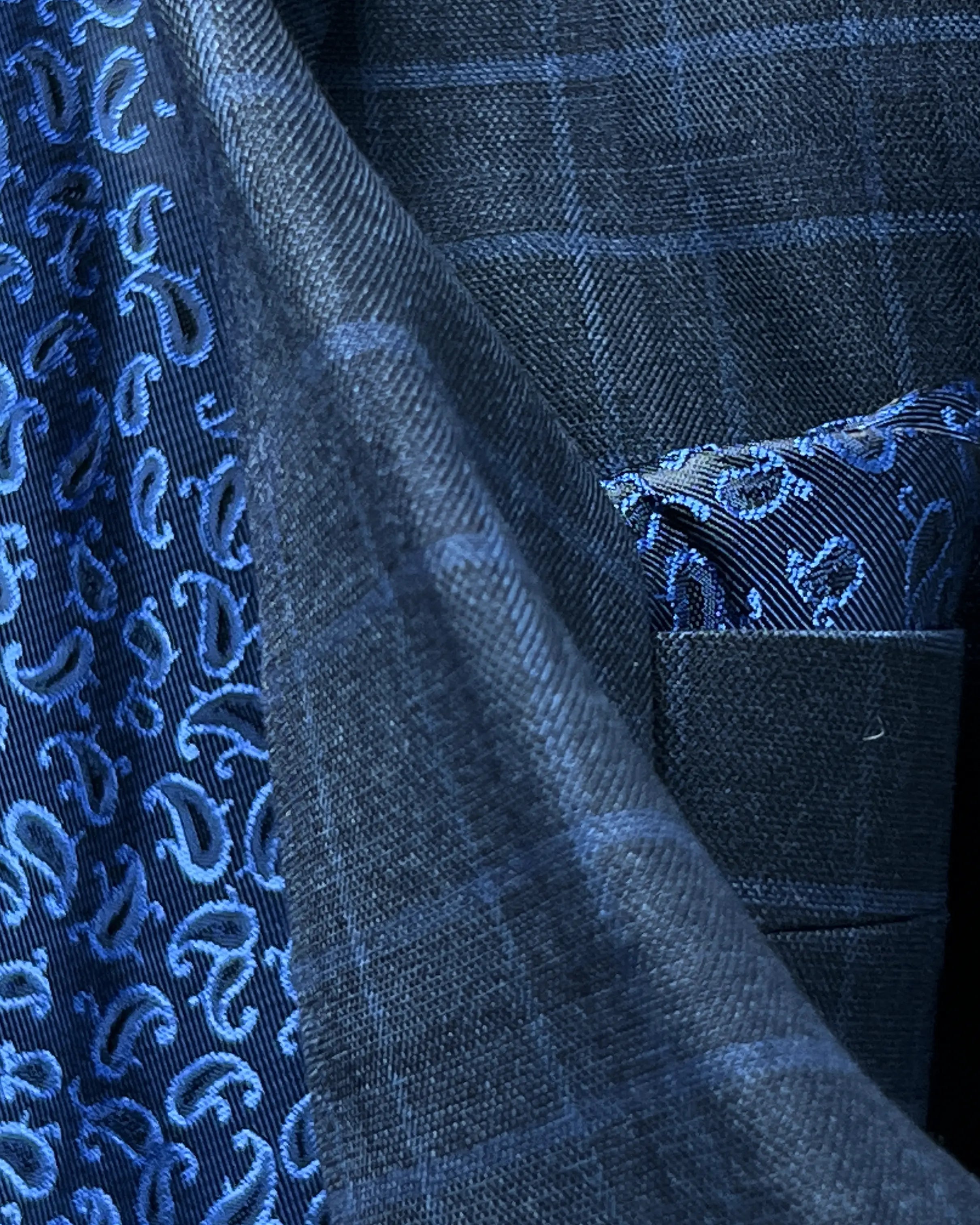 Fabric texture close up of slate blue windowpane check men's sport coat showing dry crisp high twist wool texture