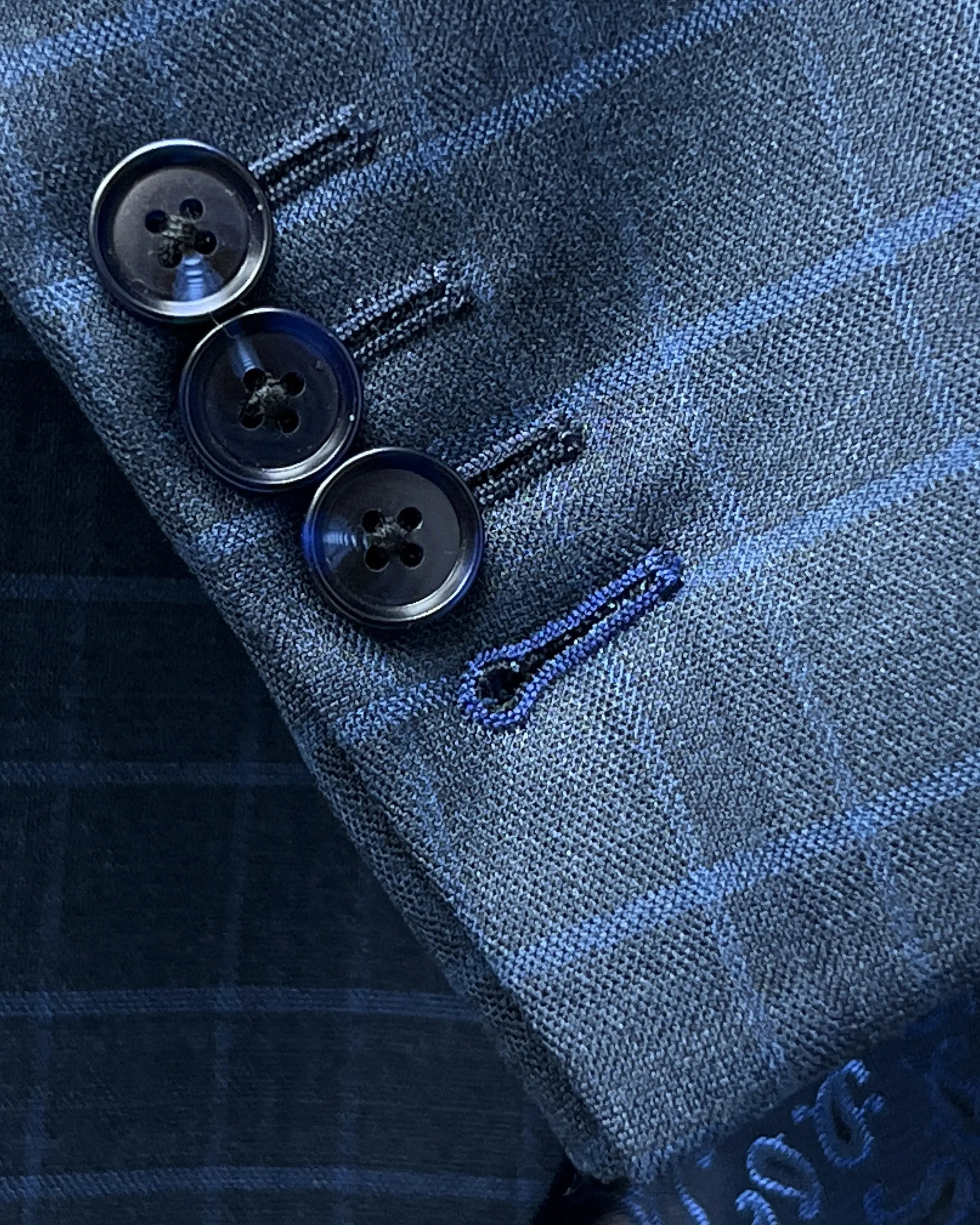 Sleeve cuff close up of slate blue windowpane check men's sport coat showing functional sleeve buttons and royal blue contrast buttonhole