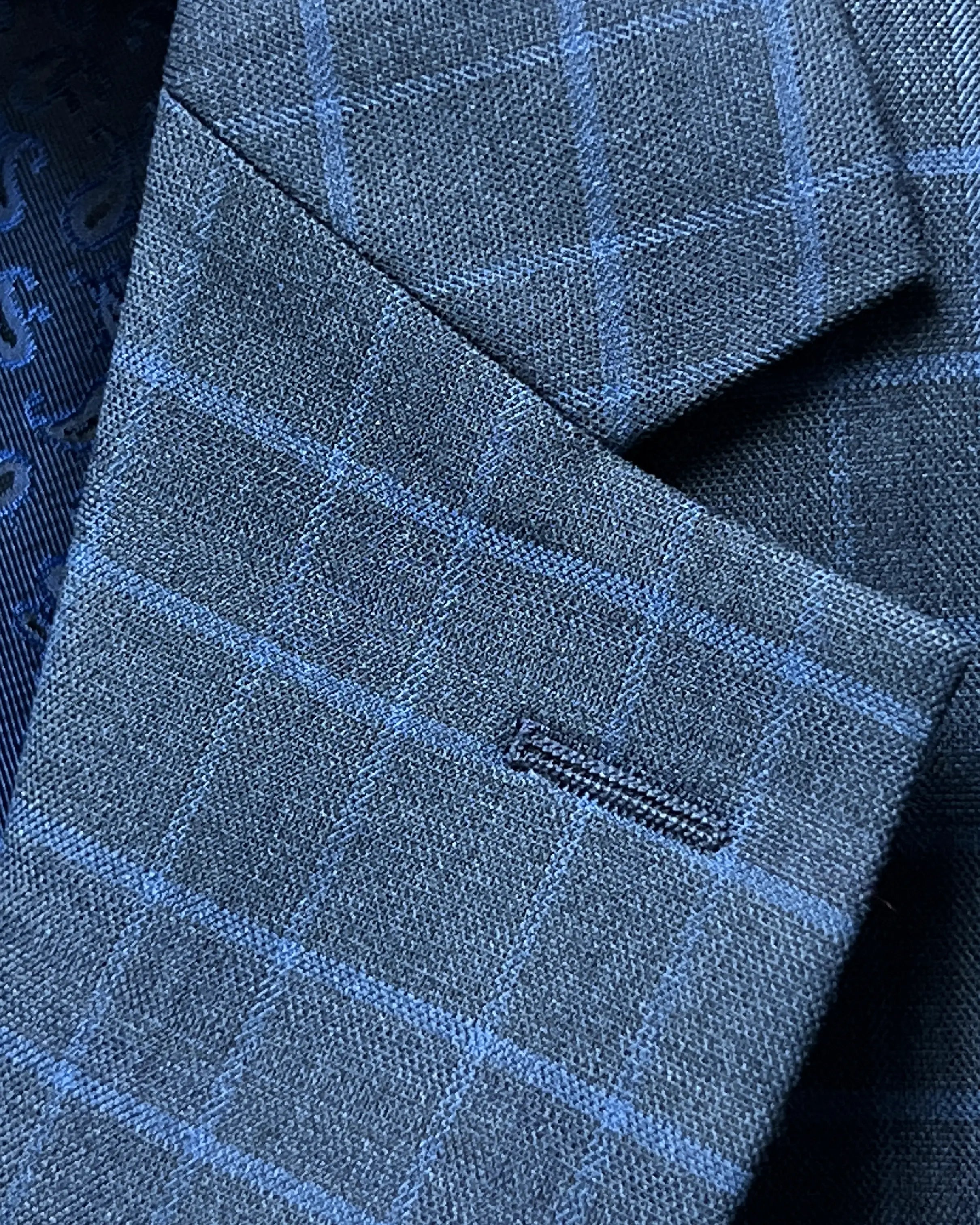 Lapel buttonhole close up of slate blue windowpane check men's sport coat showing standard lapel buttonhole stitching