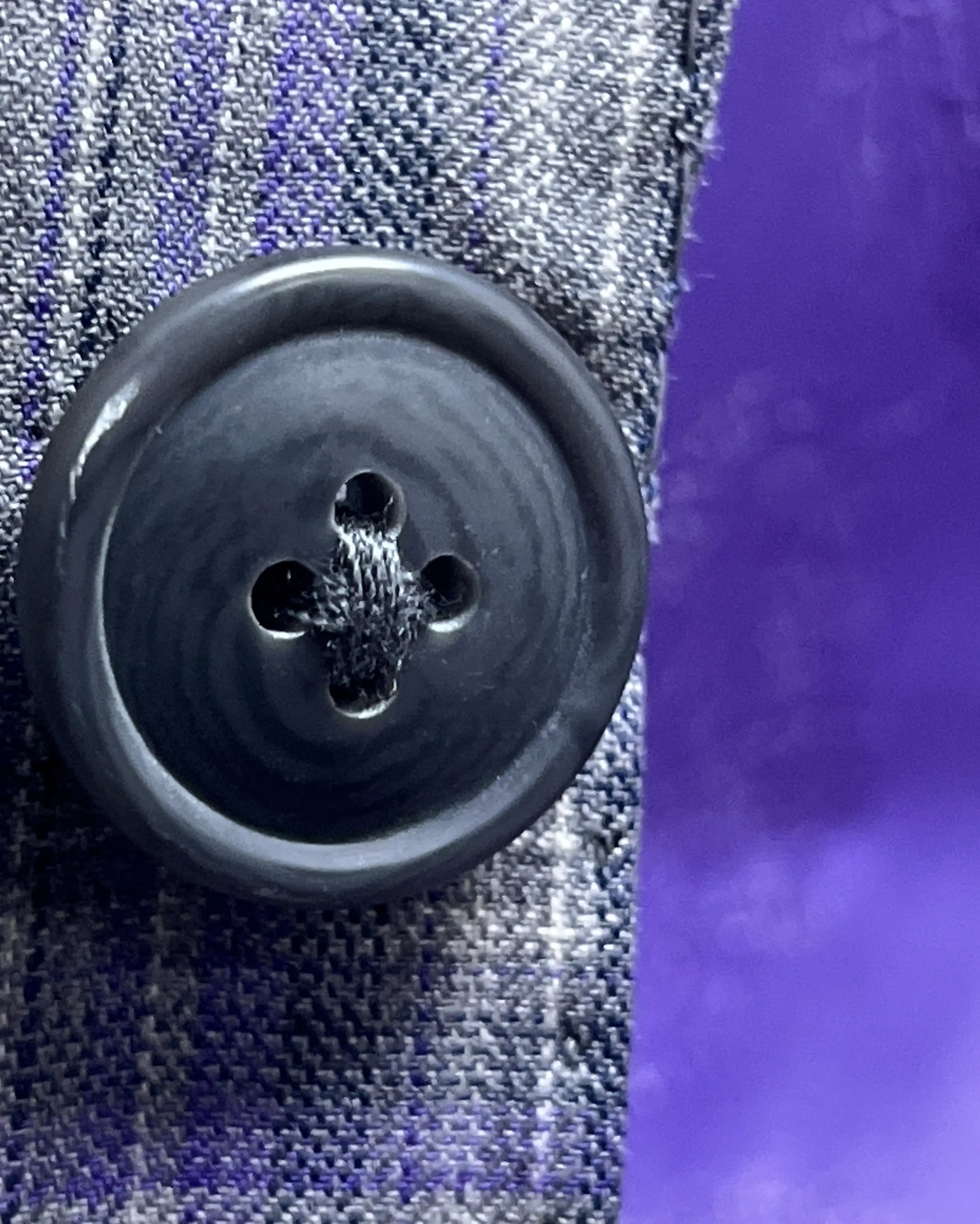 Button close up of Steel Grey Windowpane men's sport coat showing dark navy horn button material and finish.
