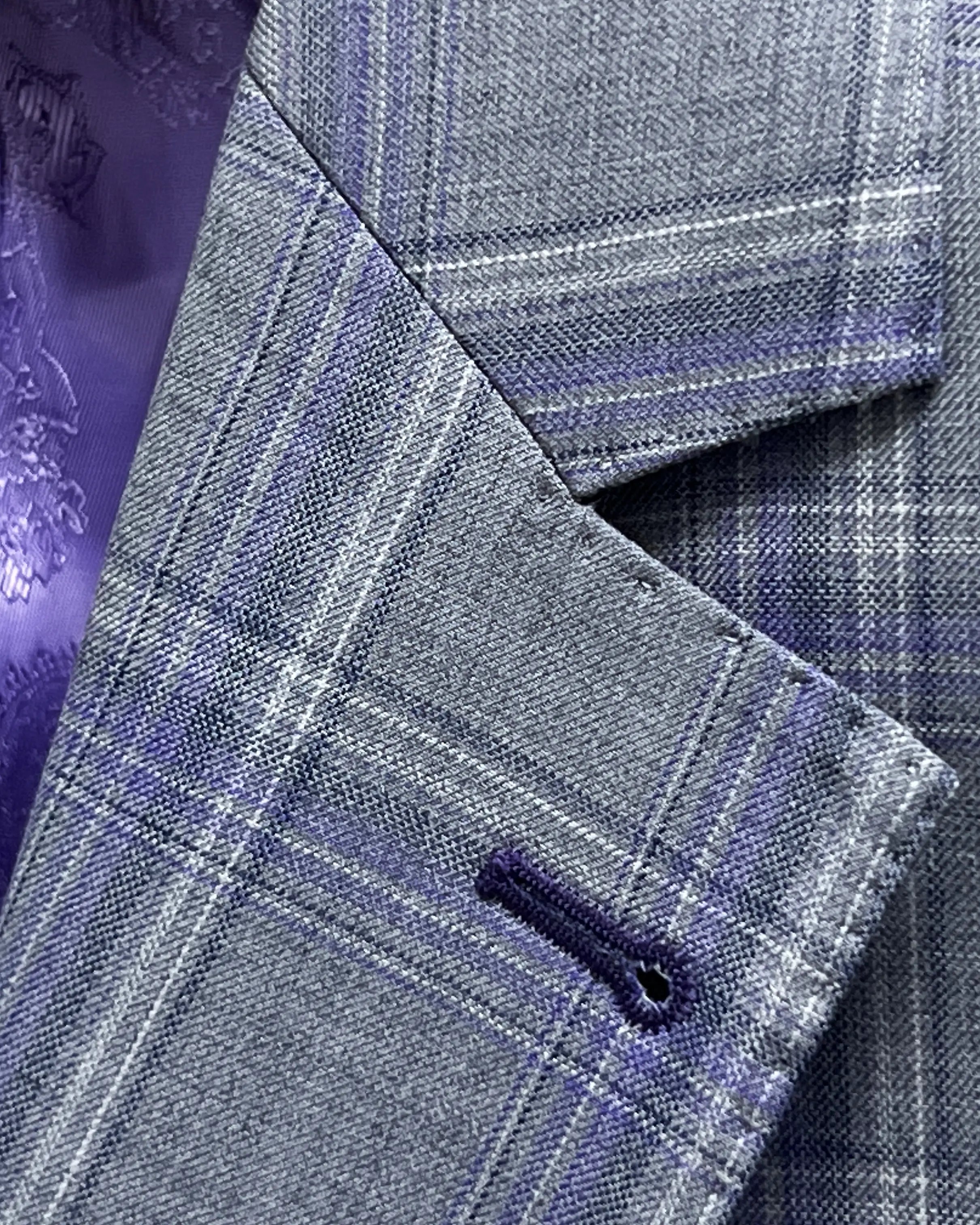 Lapel buttonhole close up of Steel Grey Windowpane men's sport coat showing deep purple contrast stitching.
