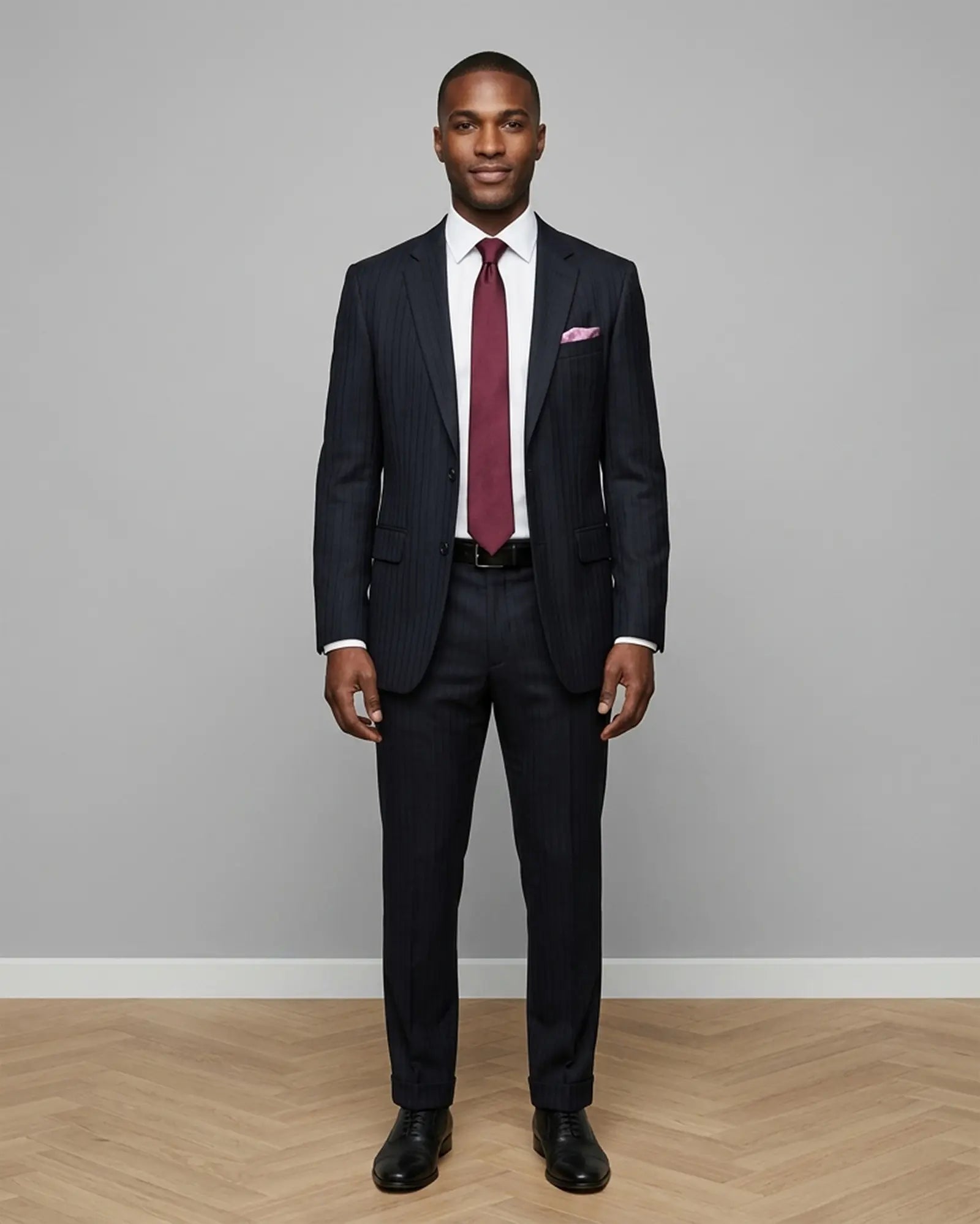 Model front view of black herringbone with shadow stripes men's suit showing the complete tailored silhouette