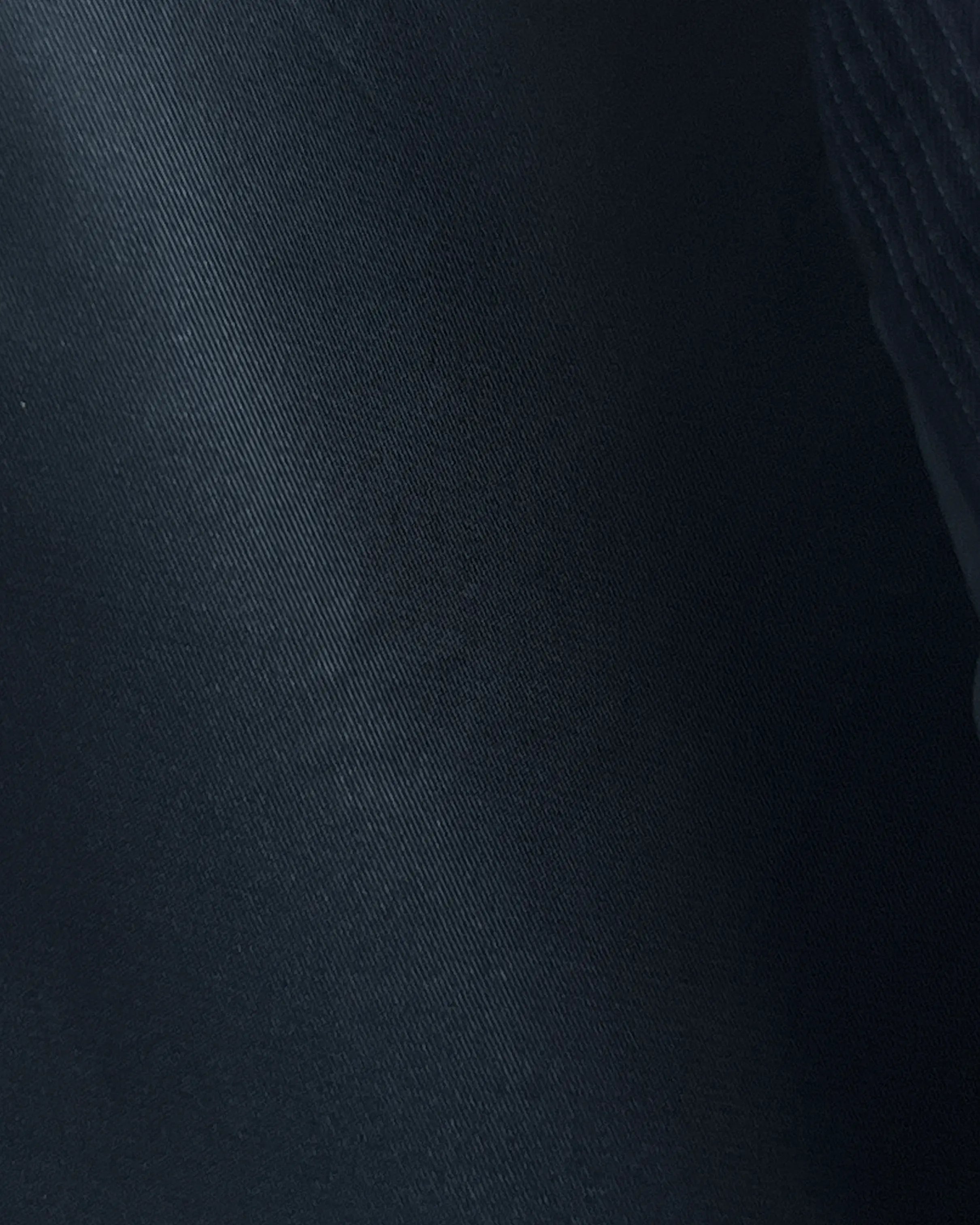 Interior detail of black pinstripe men's suit showing black silk cupro Bemberg lining and matching pocket square