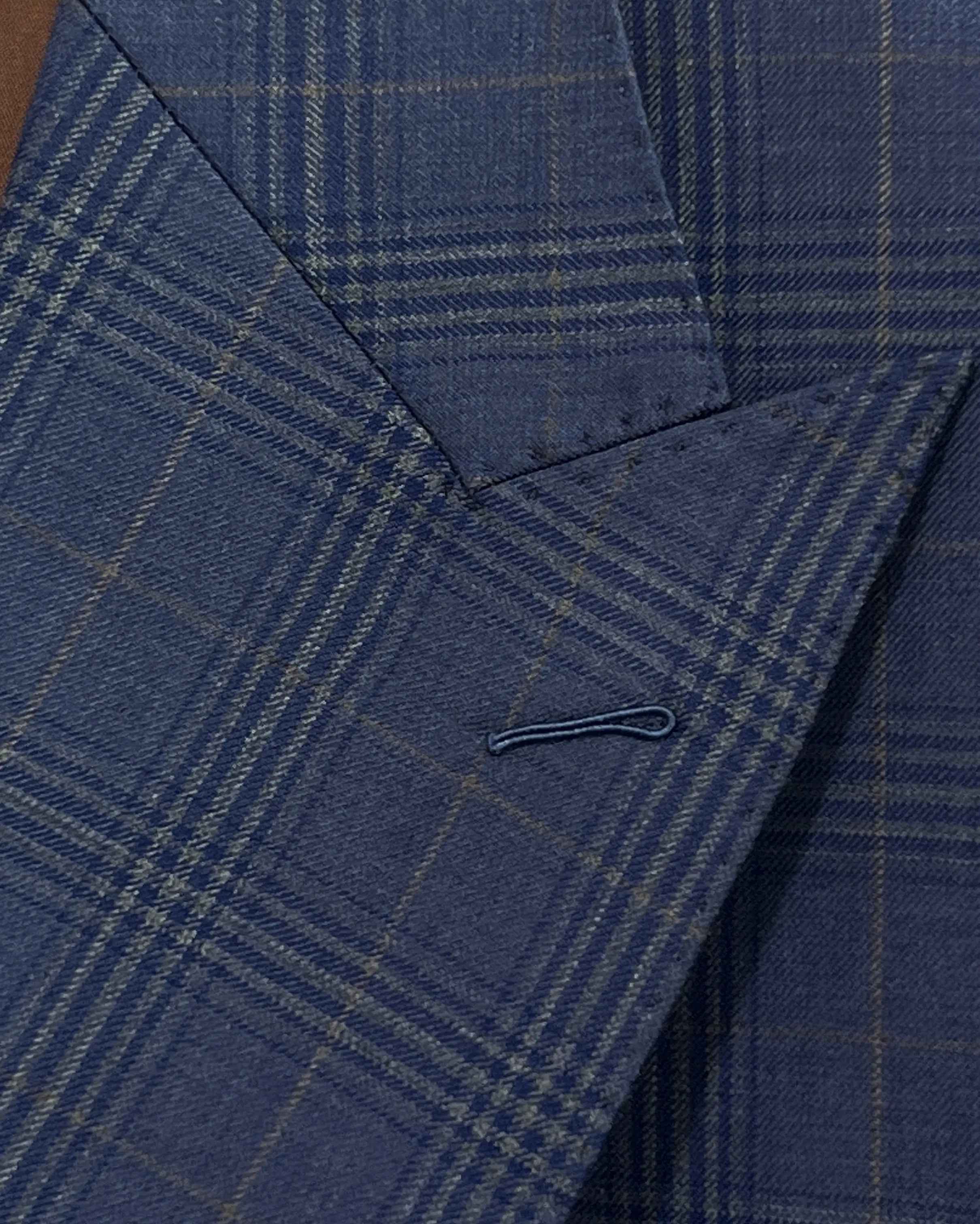 Lapel buttonhole detail of blue windowpane plaid men's suit showing standard lapel buttonhole stitching